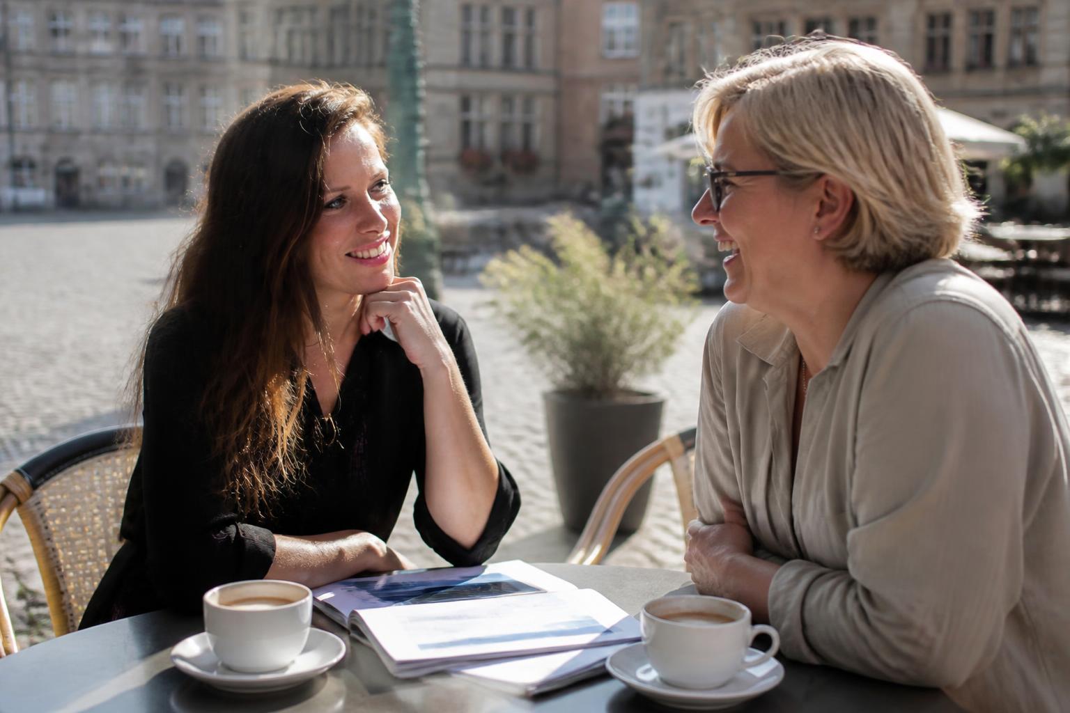 Amélie Huygens in gesprek met een ondernemer op een terras